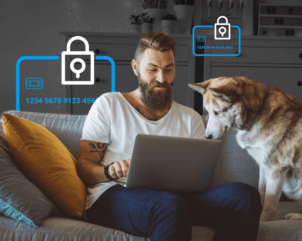 Ein junger Mann sitzt auf einer Couch und schaut auf einen Computer, während sein Hund neben ihm zusieht. Im Hintergrund sind Icons von sicheren Kreditkarten zu sehen.